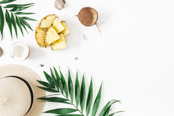 Summer composition. Tropical palm leaves, hat, pineapple, coconut on white background. Summer concept. Flat lay, top view, copy space