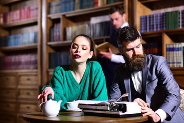 student life in university. couple in library with typewriter and teapot drinking coffee from cup....