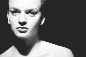 Monochrome low key portrait of beautiful woman looking at camera