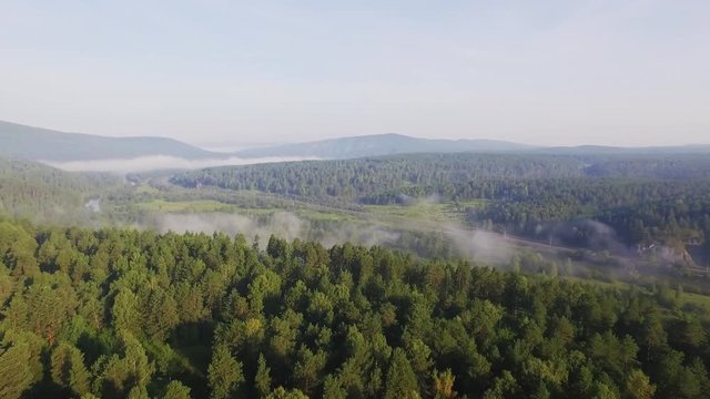 Empty railway along the river in the Ural Mountains at summer fog morning - Aerial Photography, top view