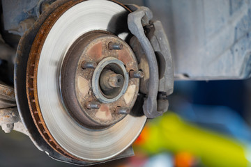 Front disc brake on car in process of service. The rim is removed showing the front rotor and...