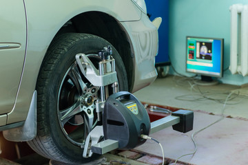 Car on stand with sensors on wheels for wheels alignment camber check in workshop of Service station