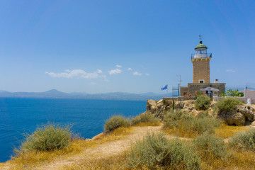 Fototapeta na wymiar Melagavi lighthouse with endless blue sea in the background in Loutraki, Peloponnese Greece