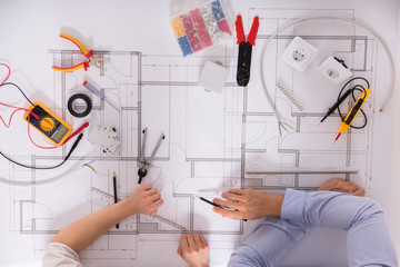 Elevated View Of Architect's Hand On Blueprint