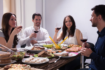 Friends Enjoying Food With Glass Of Wine