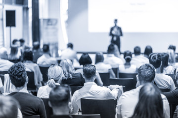 Speaker giving a talk in conference hall at business event. Focus on unrecognizable people in...