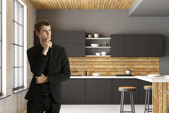 Attractive businessman in modern kitchen interior