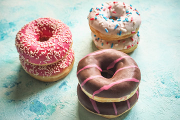 Colorful donuts on blue stone table. Top view