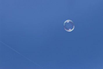 Soap bubble before bright blue sky