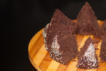 homemade chocolate cake with sesame seeds, sliced on a board