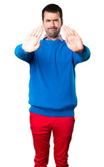 Handsome young man making stop sign on white background