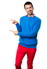 Handsome young man pointing to the lateral on white background