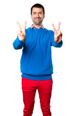 Naklejka premium Handsome young man making victory gesture on white background