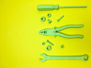 Herramientas de color verde sobre fondo amarillo.