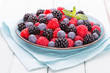 Fresh raspberries in a plate on a  vintage background.