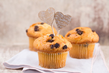 Homemade chocolate muffins with heart, vintage background.