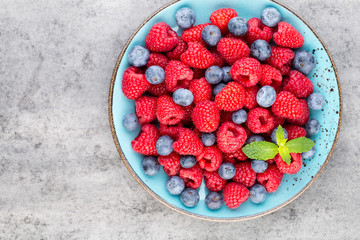 Fresh raspberries in a plate on a  vintage background.