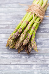 Bunch of fresh asparagus on wooden table.