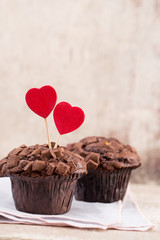 Homemade chocolate muffins with heart, vintage background.