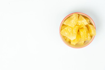 Pineapple in bowl on white background.