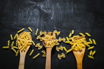 A variety on raw pasta on black background