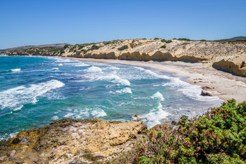Beach, Greece - Kos Island, Kefalos: Picturesque deep blue Caribbean Bay with wild sea of ​​Greek Agais and steep sandstone cliffs, perfect for wind surfers with heavy waves