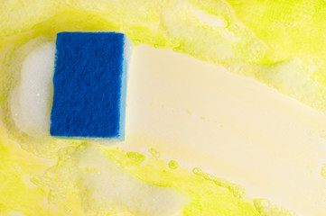 Blue sponge and foam and clean trace on dirty table