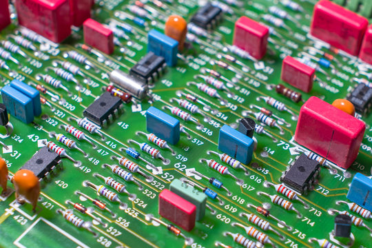 Electronic board with discrete elements, resistors, capacitors, transistors and microcircuits, close-up.