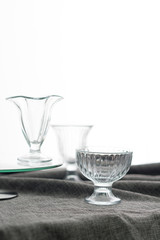3 Clean glass bowls for ice cream, with different texture, are on the table with a gray tablecloth
