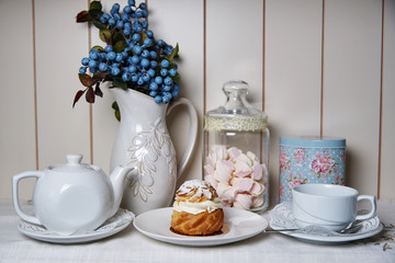 Pastry on a plate standing on a served decorated table.