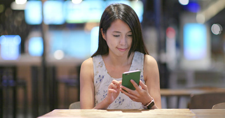 Woman use of smart phone inside restaurant