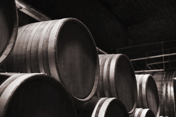 Round wooden barrels in dark winery