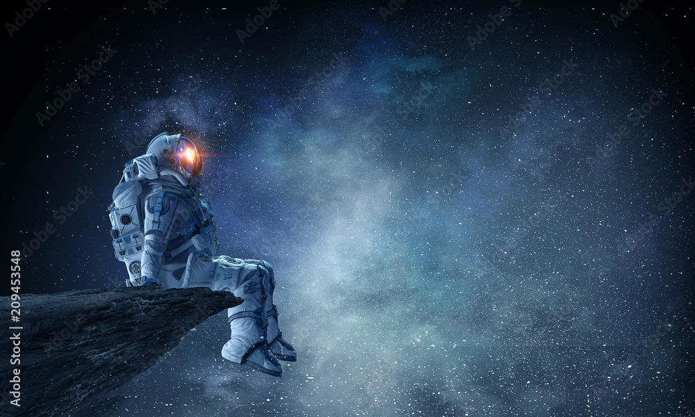 Wall mural spaceman on rock edge. mixed media