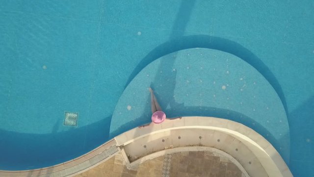 Young woman relaxing at swimming pool. Aerial footage