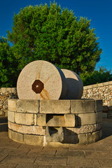 Traditional granite mill for pressing olives to obtain extra-virgin olive oil. Typical Salento farmhouse, Puglia Italy.