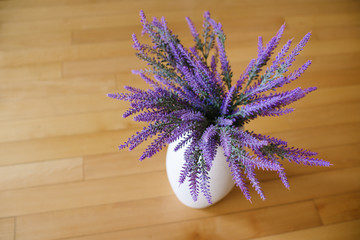 A pot with lavender on wooden background