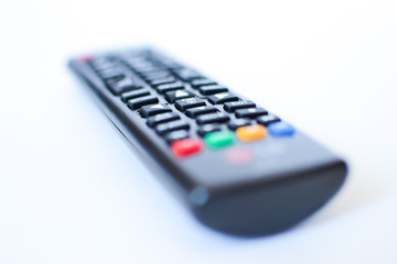 especially heavily blurred black remote controls for the TV on a white background
