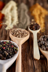 Row of wooden spoons with spices on vintage background, diminishing perspective, close-up, selective focus