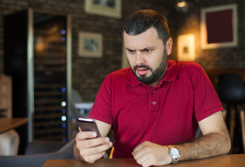 Angry man looking on mobile phone