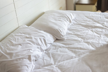 Fototapeta na wymiar home relaxation nconcept : empty white rumpled bed sheet in morning