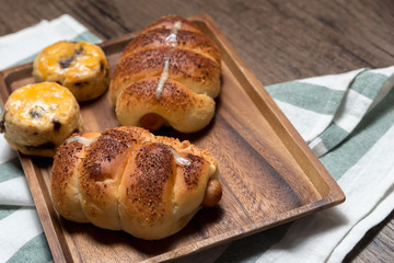 closeup delicious sausage bread roll and fresh tasty scones on wooden table