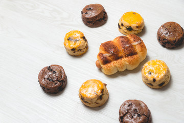 closeup delicious sausage bread roll and fresh tasty scones on wooden table