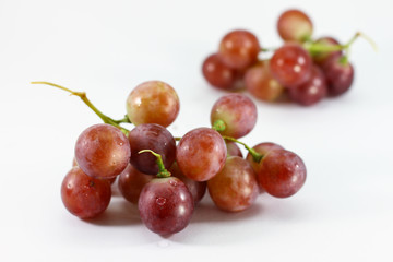 Red grapes on white background.