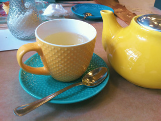Breakfast in the cafe. Teapot, Cup and saucer. Bright, colorful colors. Close-up photo.