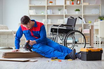 Disabled man laying floor laminate in office