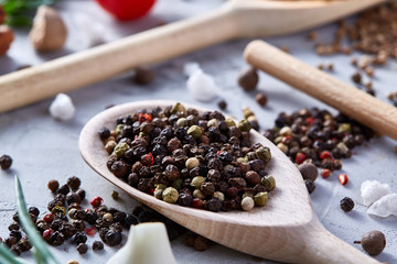 Peppercorns in wooden spoon with clipping path on white textured background, close-up, selective focus.