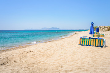 Beaches, Greece, Kos Island, Cap Helona: beautiful holiday setting on a secluded beach with umbrellas on the Greek Aegean Sea with turquoise waters and a picturesque bay and islands in the background