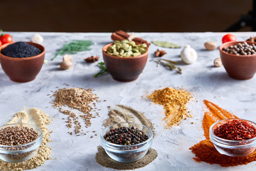 Different bowls with spices arranged in rows on white textured background, view from above.
