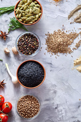 Transparent glass bowls with peppercorns and dried chilly among exotic spicies, close-up, top view, selective focus.