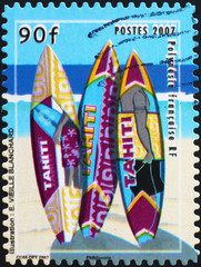 Tahiti beach and multicolored surfboards on postage stamp